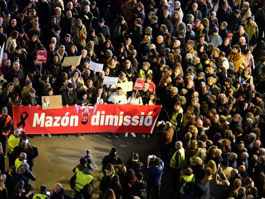 Para pengunjuk rasa memegang spanduk bertuliskan 'Carlos Mazon, Mundur' saat menuntut pengunduran diri presiden regional Valencia pada Minggu 29 Desember 2024. (JOSE JORDAN/AFP)