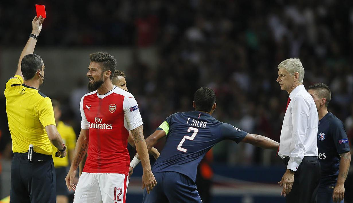 Wasit Viktor Kassai memberikan kartu merah kepada pemain Arsenal, Olivier Giroud. Laga yang berlangsung keras ini membuat wasit mengeluarkan kartu merah untuk pemain Arsenal dan PSG. (Reuters/Goonzalo Fuentes) 