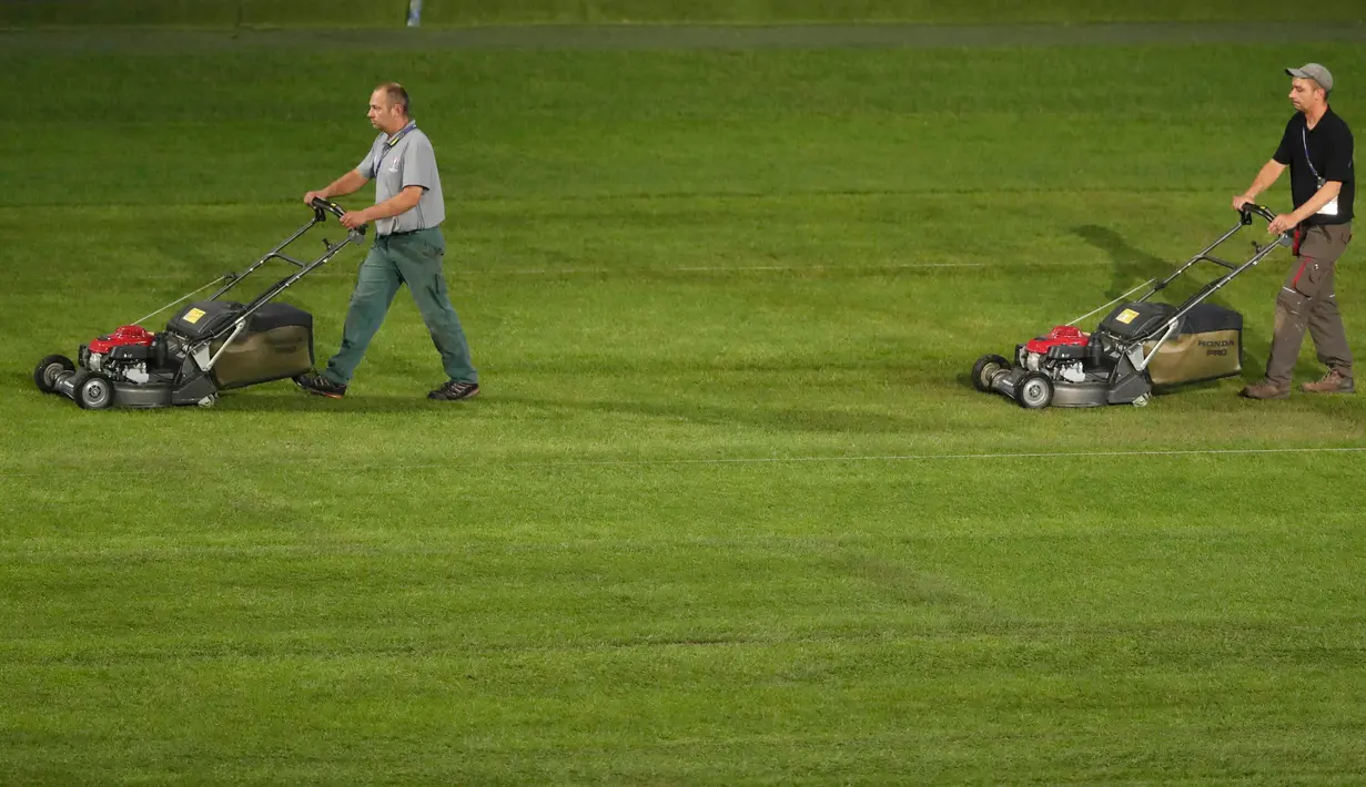 Pekerja meratakan lapangan dengan mesin pemotong rumput di Stade Pierre Mauroy, Lille, Prancis, (23/6). Jelang laga 16 besar dan final Piala Euro 2016 pihak penyelenggara memperbaiki rumput lapangan bola. (REUTERS/Carl Recine)