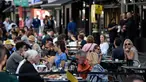 Pelanggan menikmati makan siang di meja di luar restoran di Soho, London, ketika pemerintah Inggris mempertimbangkan pembatasan baru pada Minggu (20/9/2020). Inggris kemungkinan akan kembali memberlakukan tindakan lockdown akibat lonjakan tajam infeksi virus corona COVID-19. (DANIEL LEAL-OLIVAS/AFP)