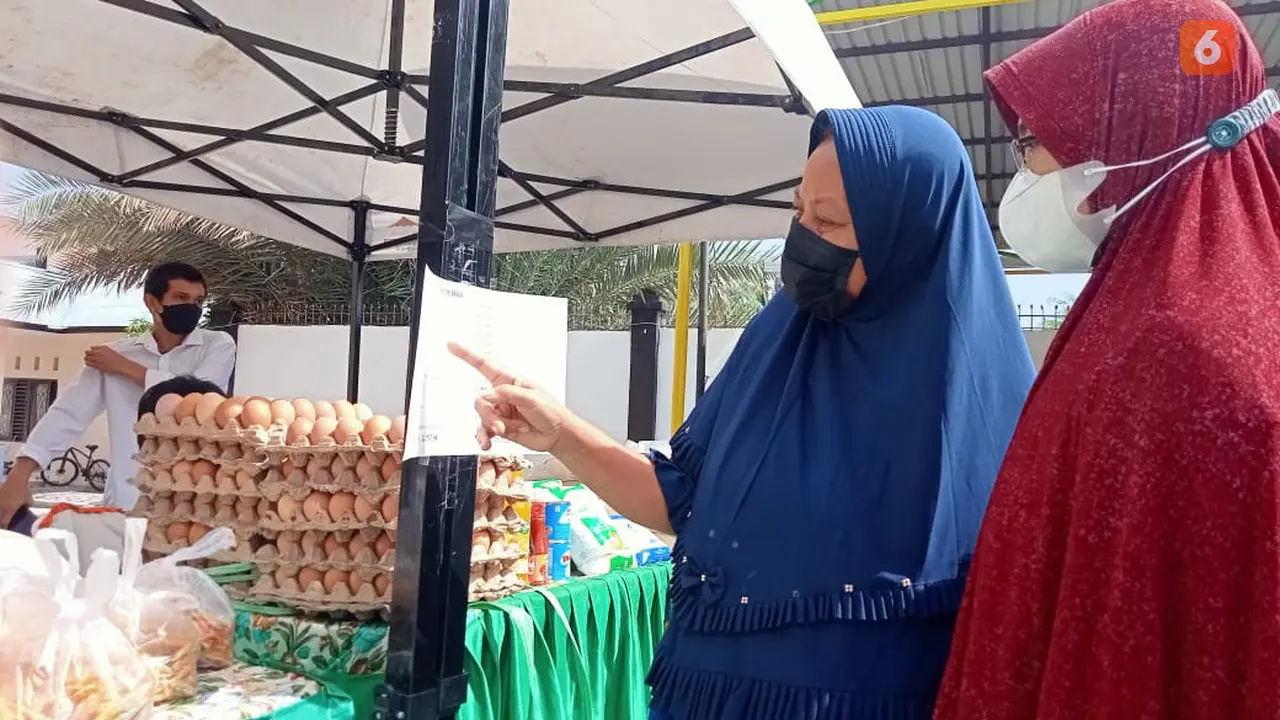 Warga melihat daftar harga kebutuhan pokok yang dijual di Pasar Tani.