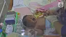 Seorang bayi menangis saat dikenakan popok oleh perawat dalam kegiatan pelatihan di RSIA Tambak, Jakarta, Kamis (18/02/2021). Melatih para ibu baru untuk memandikan bayi pertama tersebut dilakukan dengan menerapkan protokol kesehatan ketat. (Liputan6.com/Herman Zakharia)