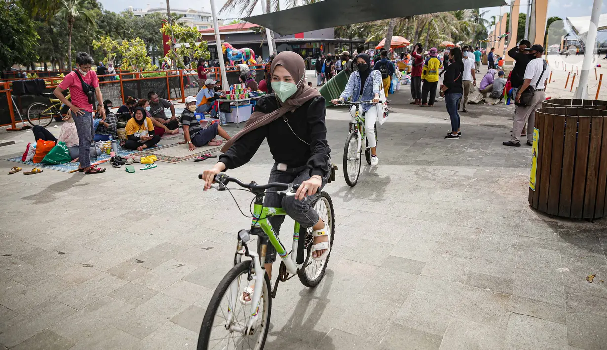 Wisatawan bersepeda di Pantai Ancol, Jakarta, Sabtu (25/12/2021). Libur Natal dimanfaatkan masyarakat berwisata ke Pantai Ancol, Kawasan Pantai Ancol merupakan salah satu objek wisata yang kerap menjadi tujuan wisatawan saat mengisi waktu liburan. (Liputan6.com/Faizal Fanani)