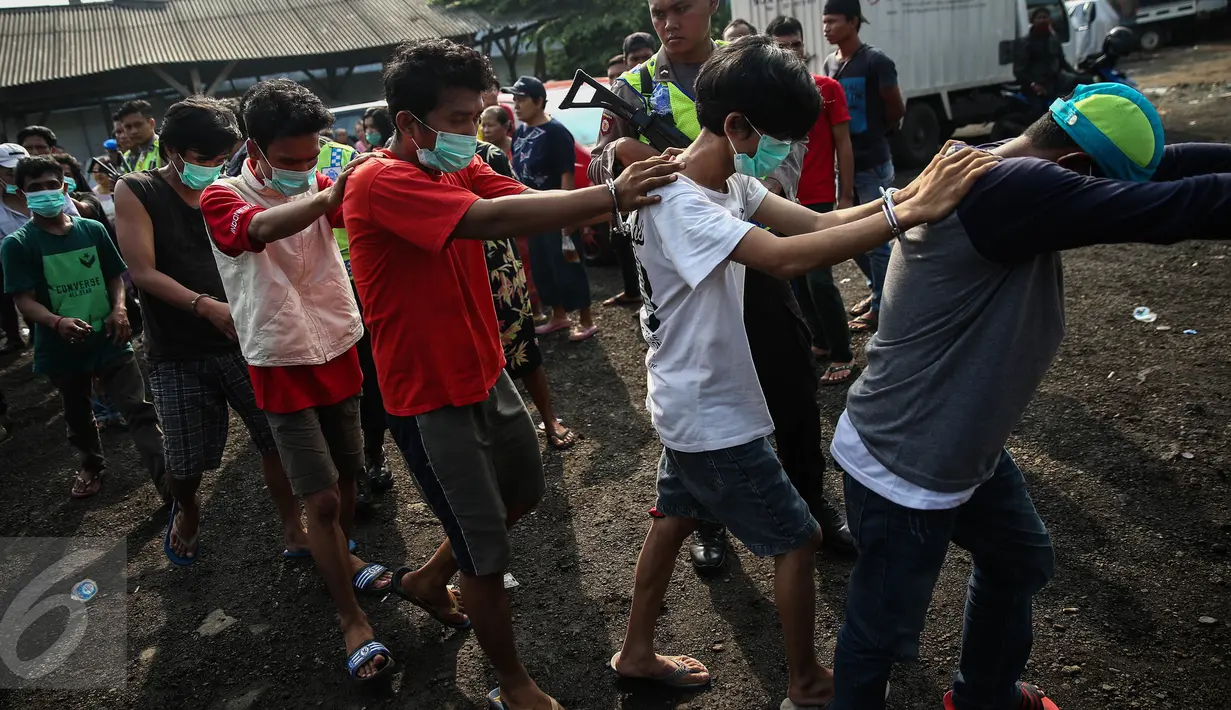 Petugas Polres Jakut mengamankan warga yang diduga sebagai pengedar dan pengguna narkoba saat penggerebekan di Kampung Bahari, Tanjung Priok, Jakarta, Kamis (25/8). Penggerebekan dipimpin Kasat Narkoba AKBP Bambang Gunawan. (Liputan6.com/Faizal Fanani)