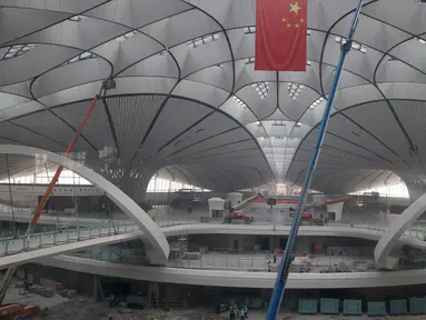 Sebuah bendera nasional Tiongkok digantung di terminal Bandara Internasional Beijing Daxing yang sedang dibangun di pinggiran Beijing, China (1/3). Bandara baru di ibu Kota China ini akan menjadi salah satu yang terbesar di dunia. (AP Photo/Ng Han Guan)