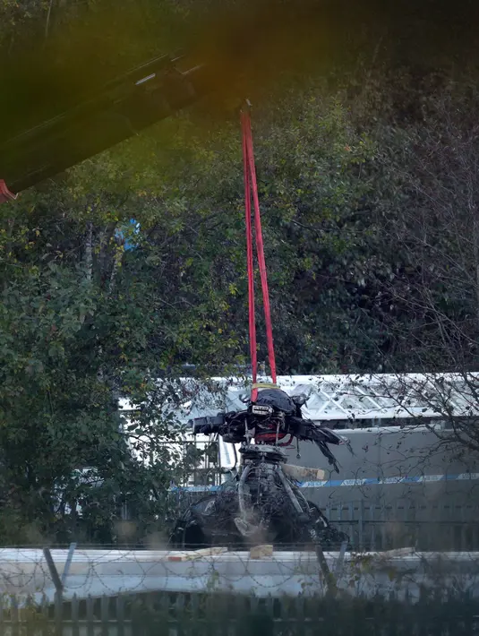Crane mengevakuasi bangkai helikopter dari lokasi kecelakaan yang menewaskan pemilik Leicester City Vichai Srivaddhanaprabha di Leicester, Inggris, Kamis (1/11). Selain Vichai, 4 orang lainnya juga tewas dalam kecelakaan tersebut. (Aaron Chown/PA via AP)