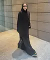Sivia mengenakan pashimina hitam panjang polos serasi dengan abaya hitam polosnya. Dipadukan kacamata hitam sambi membawa tas hitamnya. Mengenakan sepatu sneakers hijau. [@siviazizah]