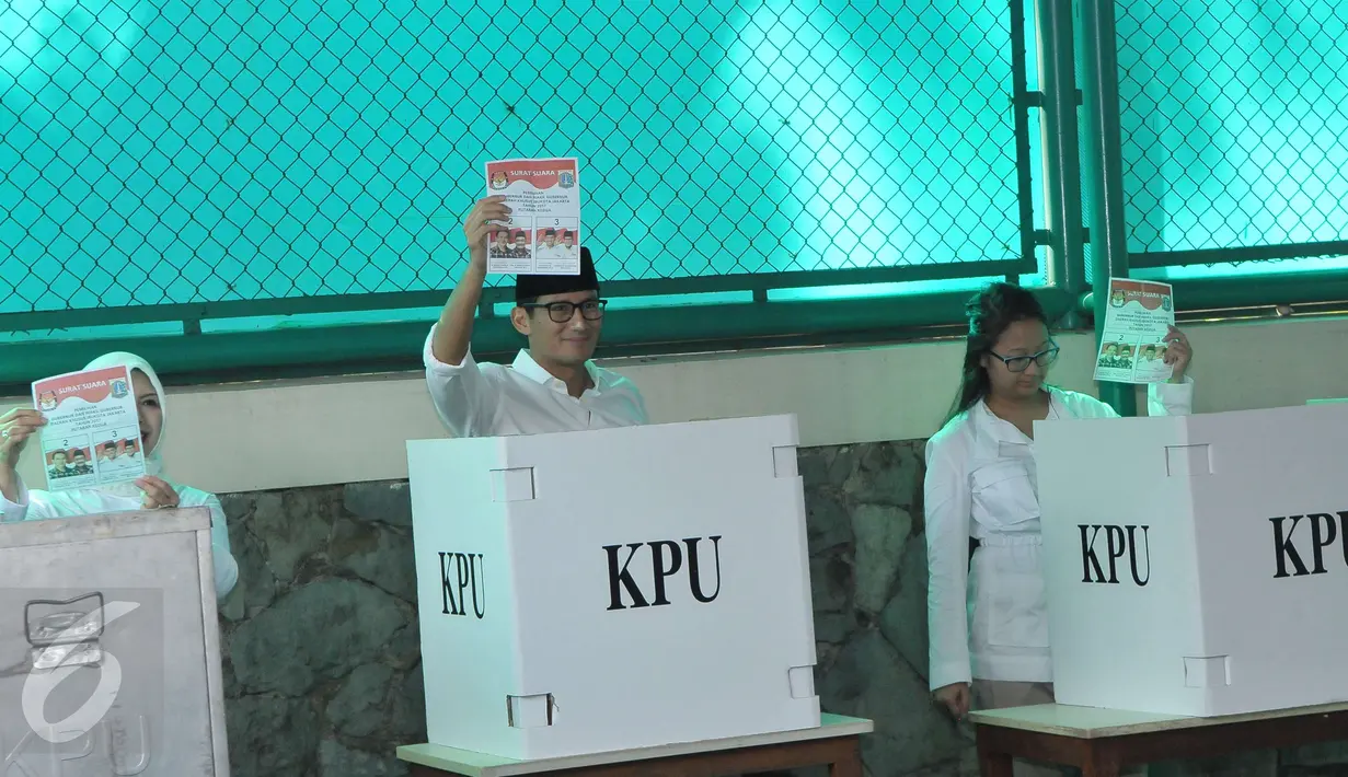 Calon Wakil Gubernur (Cawagub) DKI Jakarta, Sandiaga Uno bersama istri dan anaknya menunujukan kertas suara sebelum menyoblos dalam Pilkada Putaran kedua di TPS 01, Kebayoran Baru, Jakarta, Rabu (19/4). (Liputan6.com/Helmi Afandi)