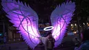 Pengunjung berpose dengan karya seni "Angels of Freedom" dari Israel yang ditampilkan selama festival seni visual tahunan Light Night Leeds di Leeds, utara Inggris, 10 Oktober 2019. Festival tersebut mengambil alih jalanan pusat kota Leeds selama dua malam di bulan Oktober. (Oli SCARFF/AFP)