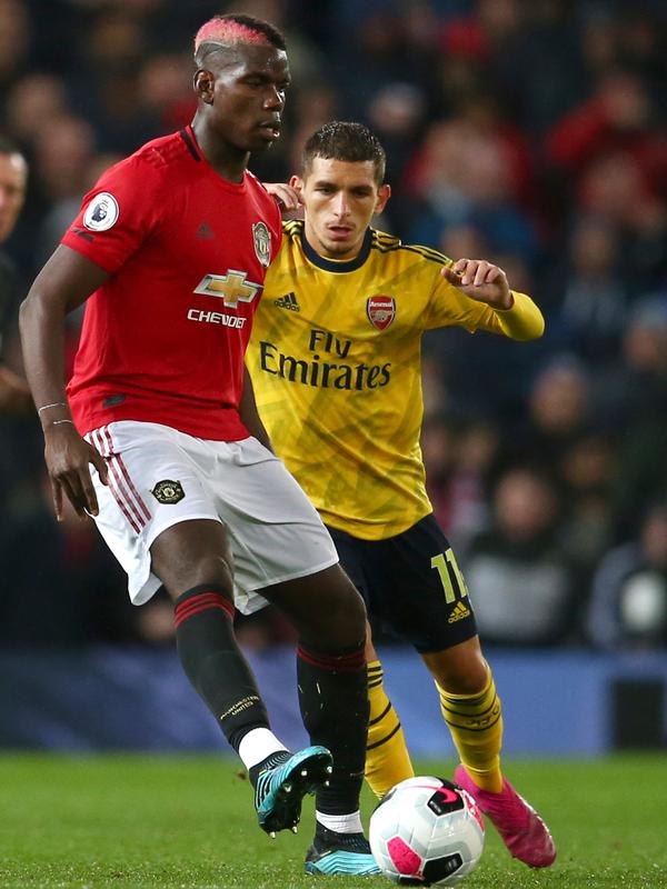 Pemain Manchester United Paul Pogba (kiri) berebut bola dengan pemain Arsenal Lucas Torreira dalam lanjutan Liga Inggris di Old Trafford, Manchester, Inggris, Senin (30/9/2019). Pertandingan berakhir 1-1. (AP Photo/Dave Thompson)