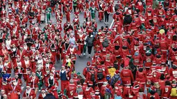 Berbeda dengan lomba lari biasa, dalam ajang tahunan ini para peserta beraksi di lintasan dengan mengenakan kostum Santa Claus yang didominasi warna merah, lengkap dengan janggut putih dan topi. Tampak dalam foto, ribuan pelari yang mengenakan kostum Santa Claus berpartisipasi dalam edisi ke-14 lomba Santa Claus, sebuah lari santai sejauh 4,5 km melalui jalan-jalan Madrid pada Minggu 21 Desember 2025. (OSCAR DEL POZO/AFP)