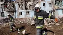 Tim penyelamat Ukraina memindahkan puing-puing dari bangunan tempat tinggal berlantai lima yang hancur setelah serangan rudal di tengah invasi Rusia ke Ukraina di Zaporizhzhia pada 2 Maret 2023. Serangan Rusia di sebuah blok apartemen di kota Zaporizhzhia, Ukraina selatan telah menewaskan sedikitnya tiga orang, kata pihak berwenang setempat pada 2 Maret, saat operasi pencarian sedang berlangsung. (AFP/Katerina Klochko)