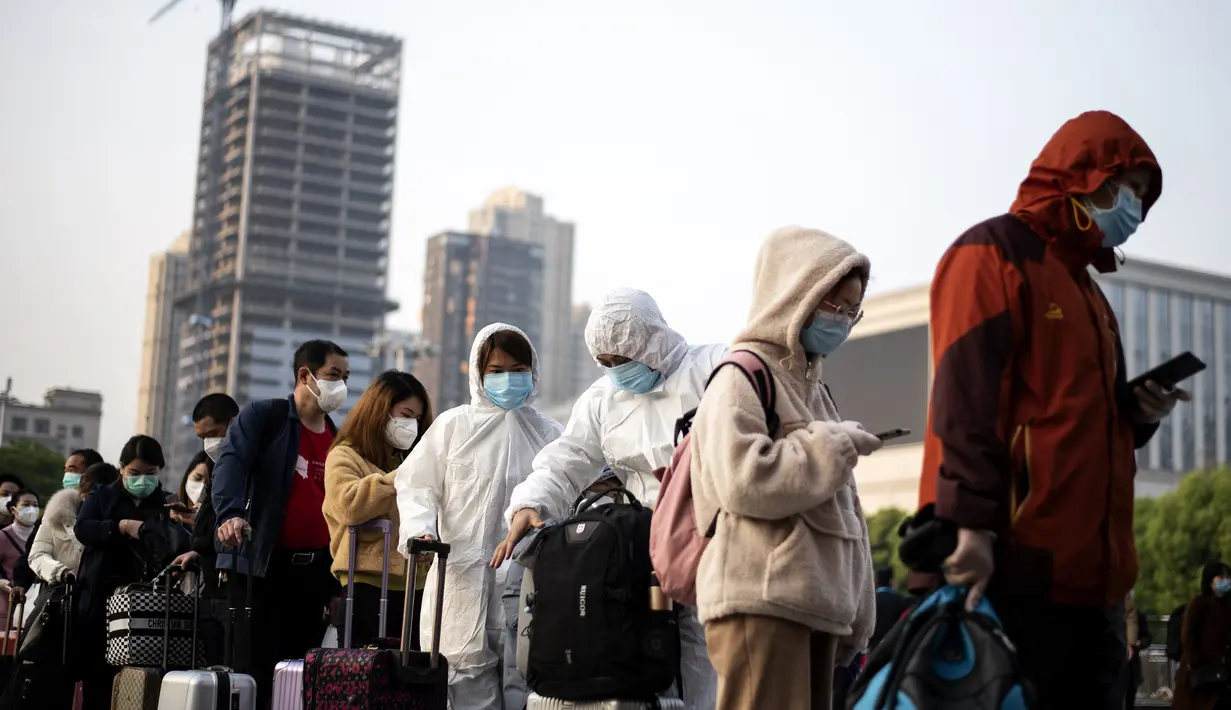 Warga yang mengenakan masker hingga pakaian pelindung tiba di Stasiun Hankou, Wuhan, Hubei, China, Rabu (8/4/2020). Setelah pandemi virus corona COVID-19 mereda, banyak warga di Wuhan beraktivitas memakai masker, sarung tangan, pelindung wajah, hingga pakaian pelindung. (NOEL CELIS/AFP)