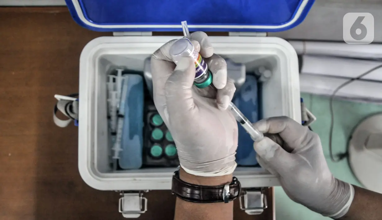 Tim paramedis Suku Dinas Ketahanan Pangan, Kelautan, dan Pertanian Jakarta Timur menyiapkan vaksin rabies untuk disuntikkan kepada hewan peliharaan warga di Kantor RW 07 Cipinang Muara, Jatinegara, Jakarta, Senin (6/9/2021). Vaksinasi keliling ini digelar di tiap RW. (merdeka.com/Iqbal S. Nugroho)