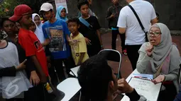 Sejumlah anak mengamati aksi sosialisasi bahasa isyarat di Car Free Day (CFD), Jakarta, Minggu (11/9). Sosialisasi belajar bahasa isyarat untuk mengkampanyekan penggunaan bahasa isyarat dalam dialog para penyandang tuna rungu. (Liputan6.com/Faizal Fanani)