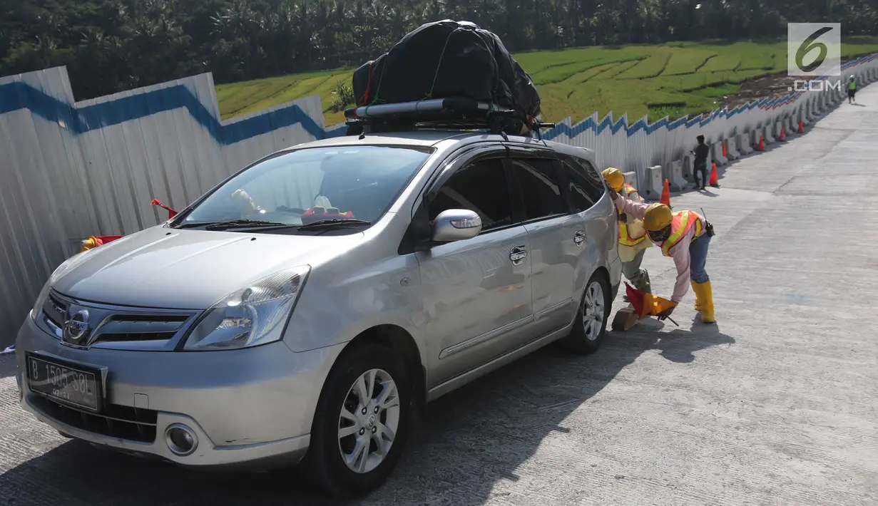 Petugas membantu kendaraan pemudik yang tidak kuat melaju di tanjakan Kali Kenteng, ruas tol fungsional Salatiga-Kartasura, Susukan, Kabupaten Semarang, Jawa Tengah, Selasa (12/6). (Liputan6.com/Arya Manggala)