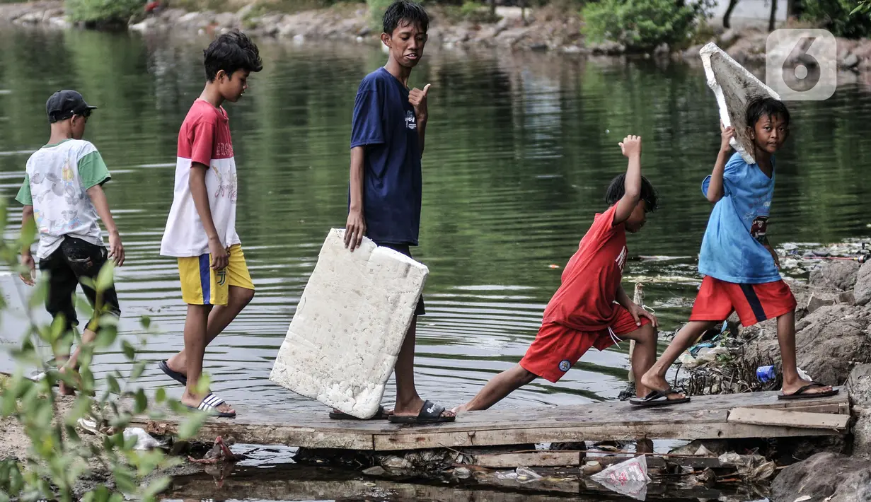 Anak-anak saat akan berenang di rawa pesisir Muara Baru, Cilincing, Jakarta, Minggu (15/8/2021). Anak-anak setempat memanfaatkan rawa sebagai wahana berenang akibat keterbatasan lahan bermain di wilayah pesisir tersebut. (merdeka.com/Iqbal S Nugroho)