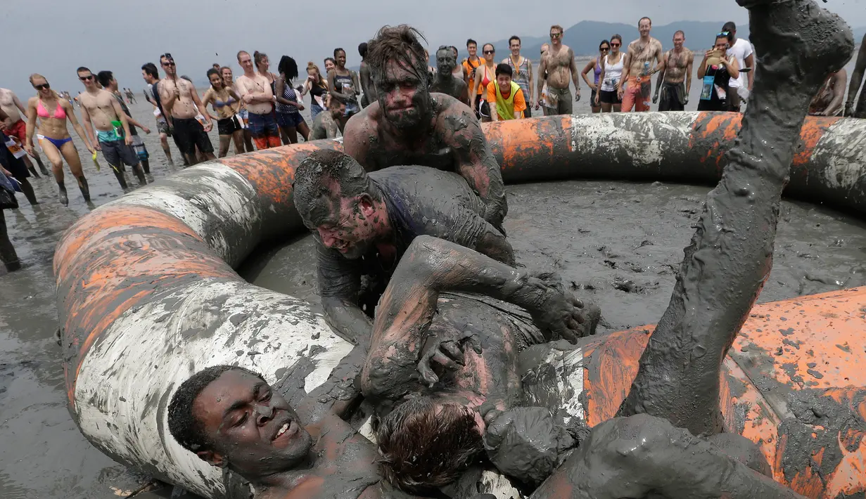 Turis mengikuti permainan dalam Festival lumpur Boryeong di Daecheon, Boryeong, Korea Selatan, (22/7). Festival lumpur tahunan ke-20 ini selalu mengadakan berbagai perlombaan yang menggunakan arena berlumpur. (AP Photo/Ahn Young-joon)