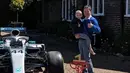Bocah penderita kanker tulang langka Harry Shaw digendong ayahnya melihat mobil F1 yang dia terima dari Lewis Hamilton di Redhill, Surrey, Inggris, 13 Mei 2019. Hamilton menghadiahi mobil Mercedes yang dipakai dalam balapan F1 kepada bocah berusia lima tahun tersebut. (James Shaw/via REUTERS)