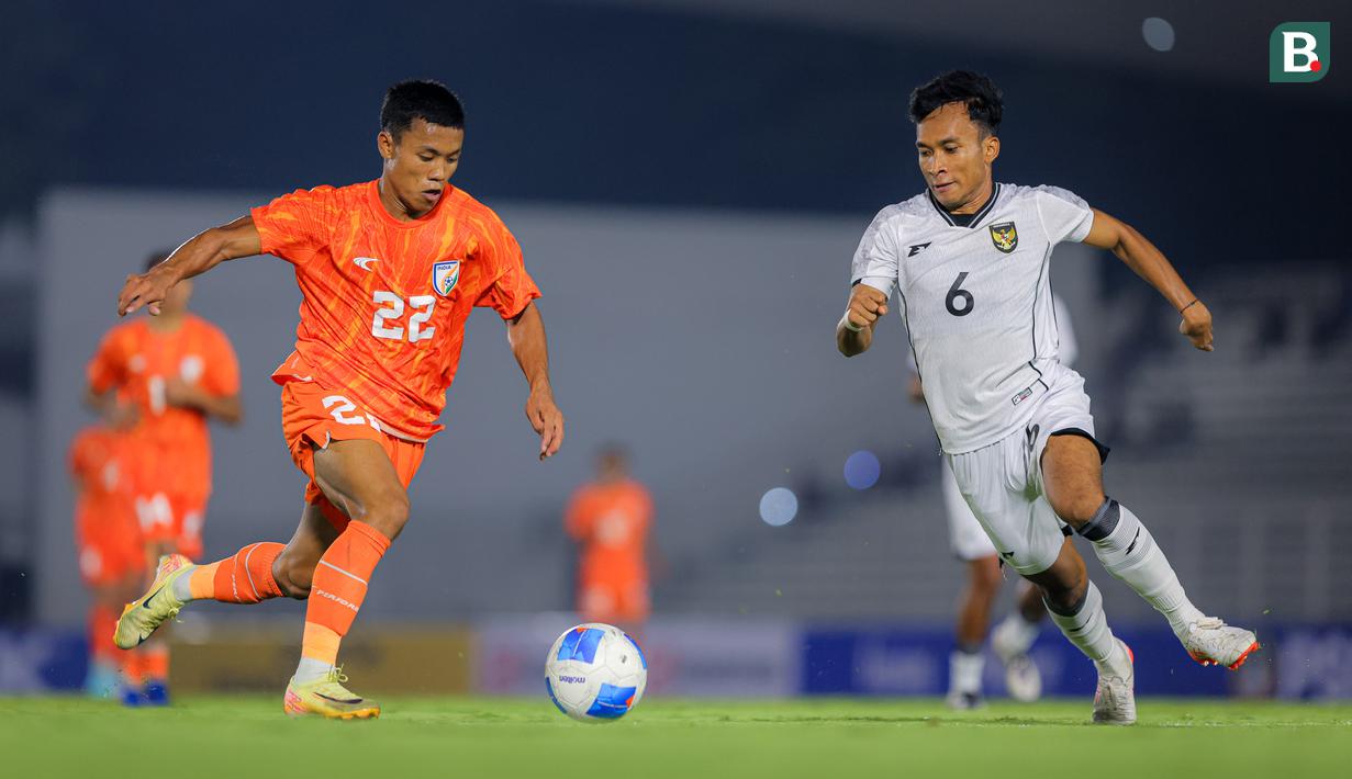 Pemain Timnas Indonesia U-22, Rabi Darwis (kanan) berebut bola dengan pemain India, Thingujam Korou Singh dalam laga uji coba di Stadion Madya, Senayan, Jakarta, Minggu (13/10/2025). (Bola.com/Bagaskara Lazuardi)
