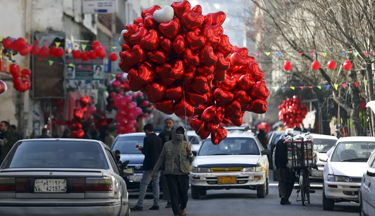 Seorang pria menjual balon pada Hari Valentine di Kabul, Afghanistan, Minggu (14/2/2021). Hari Valentine menjadi budaya baru dalam masyarakat Afghanistan yang konservatif. (AP Photo/Rahmat Gul)