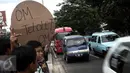 Anak-anak  saat meminta bunyi klakson telolet ke bus yang lewat di Jalan Raya Bogor, Jakarta, Sabtu (24/12). Fenomena ini mendunia setelah beberapa artis dan tokoh terkenal dunia berkomentar di media sosial. (Liputan6.com/ Faizal Fanani)
