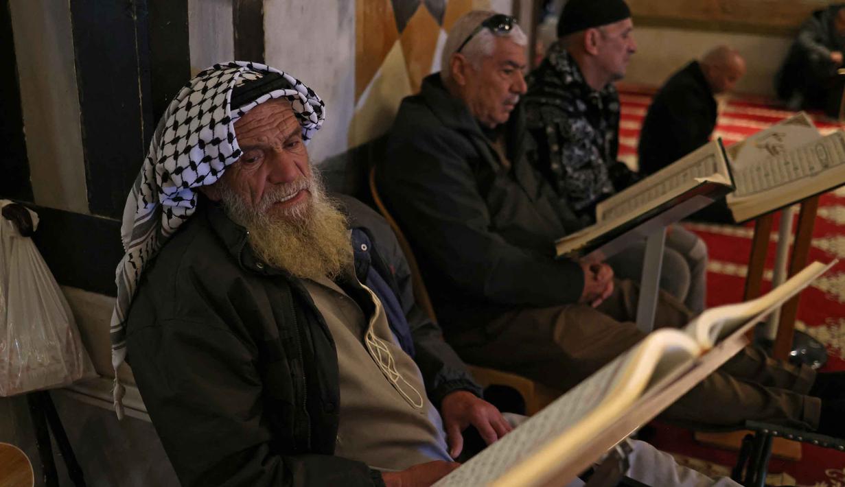 Bagi umat Muslim, membaca Al-Quran di dalam Kubah Batu di kompleks Masjid al-Aqsa adalah pengalaman spiritual yang sangat berkesan. Tampak dalam foto, para pria Palestina membaca Al-Quran di dalam Kubah Batu di kompleks Masjid al-Aqsa, Yerusalem menjelang waktu berbuka puasa selama bulan suci Ramadan 1447 Hijriah pada Rabu 25 Februari 2026. (AHMAD GHARABLI/AFP)