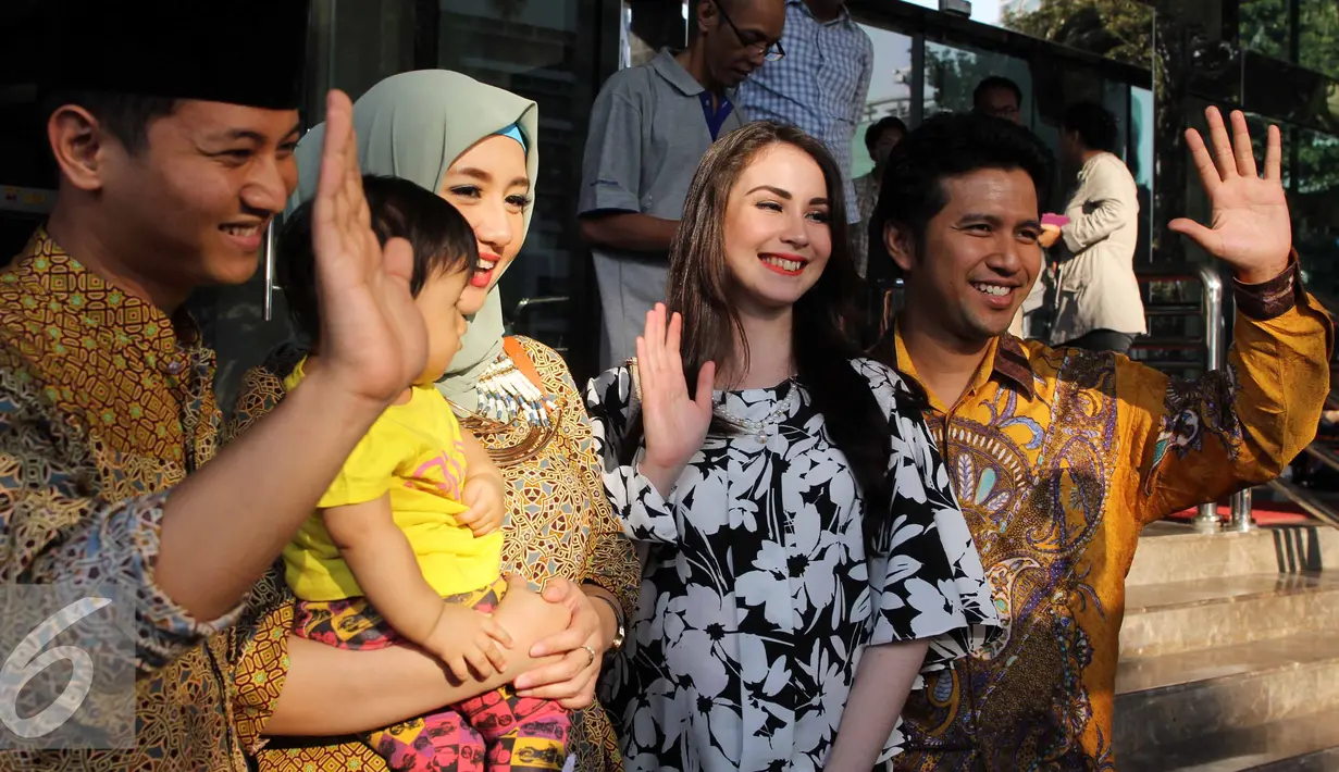 Arumi Bachsin (kedua kanan) dan suaminya Emil Elistianto Dardak (kanan) berpose di depan kantor KPK saat akan menyerahkan Laporan Harta Kekayaan Penyelenggara Negara (LHKPN) ke KPK, Jakarta, Senin (3/8/2015). (Liputan6.com/Helmi Afandi)