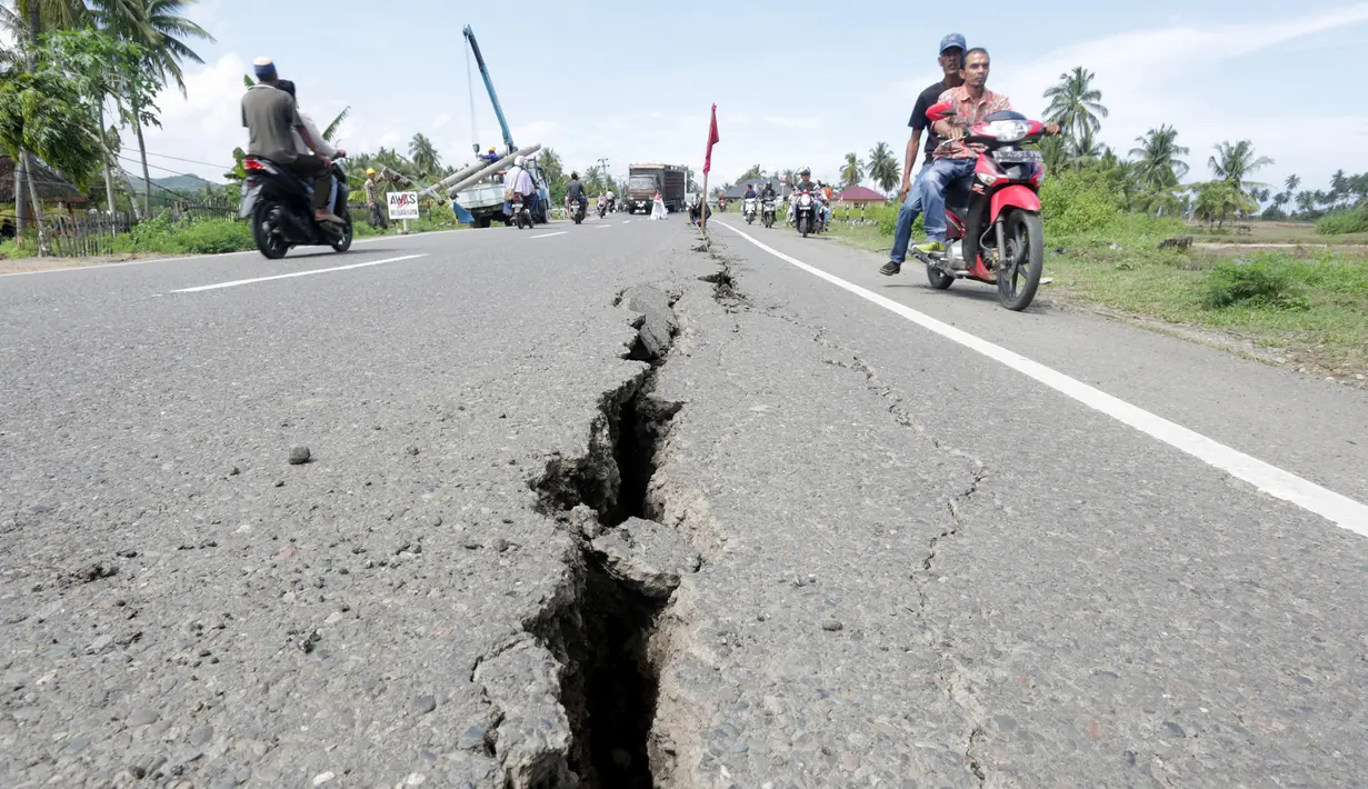 Kondisi jalan yang rusak usai gempa bumi di Meuredu, Pidie Jaya Aceh, Rabu (7/11). Selain meruntuhkan bangunan, gempa bumi berkuatan 6,4 SR ini telah menelan banyak korban jiwa. (Antara Foto / Irwansyah Putra / via REUTERS)