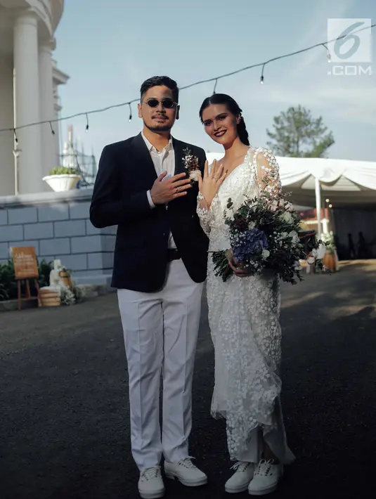 Penyanyi Petra Sihombing menunjukkan cincin pernikahannya dengan Firrina Sinatrya usai pemberkatan di GPIB Immanuel, Jakarta, Jumat (23/3). Petra resmi mempersunting Firrina yang dipacarinya selama dua tahun. (Liputan6.com/Faizal Fanani)