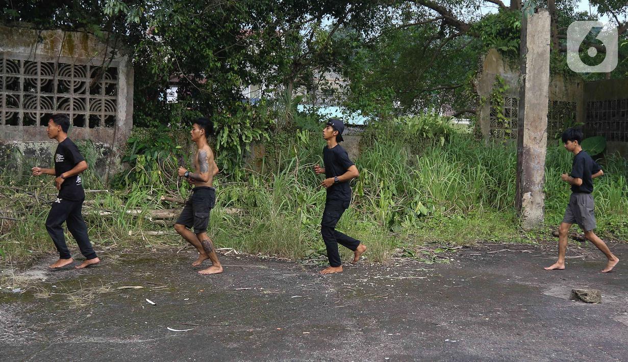 Pemain dari kelompok barongsai Naga Merah Putih Bogor melakukan pemanasan sebelum latihan dengan Barongsai dan Liong di kawasan Babakan Pasar, Kota Bogor, Jawa Barat, Rabu (11/1/2023). Latihan tersebut  untuk mempersiapkan penampilan menyambut Tahun Baru Imlek. (Liputan6.com/Herman Zakharia)