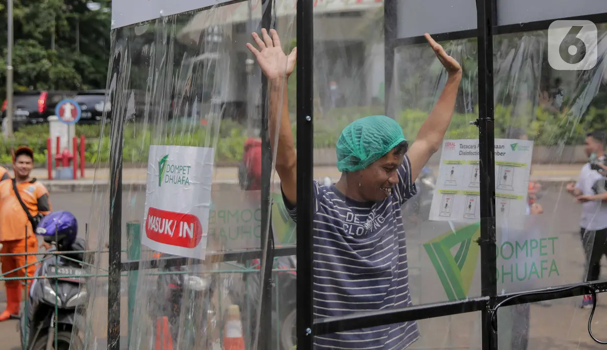 Warga masuk dalam ruang khusus semprot Desinfektan Chamber di depan Pasar Raya Blok M, Jakarta, Selasa (24/3/2020). Pamasangan ruang khusus semprot Desinfektan Chamber untuk mensterilkan full body masyarakat untuk menekan penyebaran Covid-19. (Liputan6.com/Faizal Fanani)
