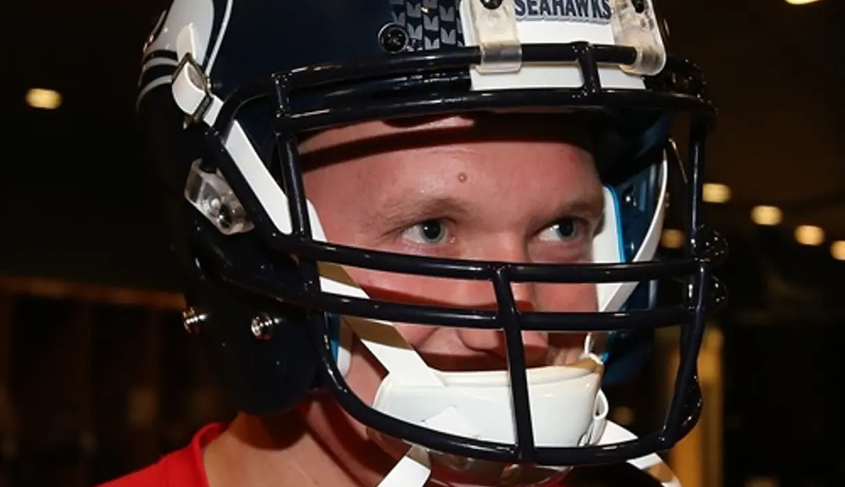Phil Jones mencoba perlengkapan American Football. (Manutd.com)