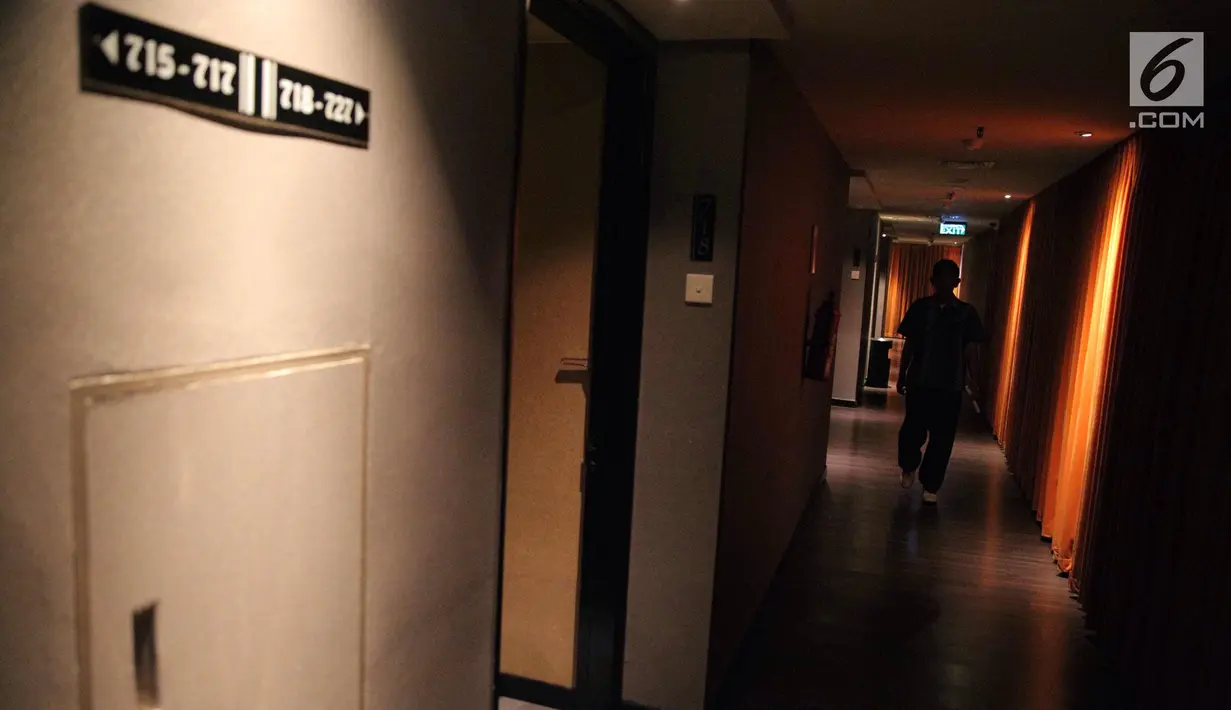 Seorang pria berjalan di lorong yang berada di lantai tujuh Hotel Alexis, Jakarta, Selasa (31/10). Suasana pencahayaan yang kurang dan udara dingin terasa di lantai itu. (Liputan6.com/Faizal Fanani)