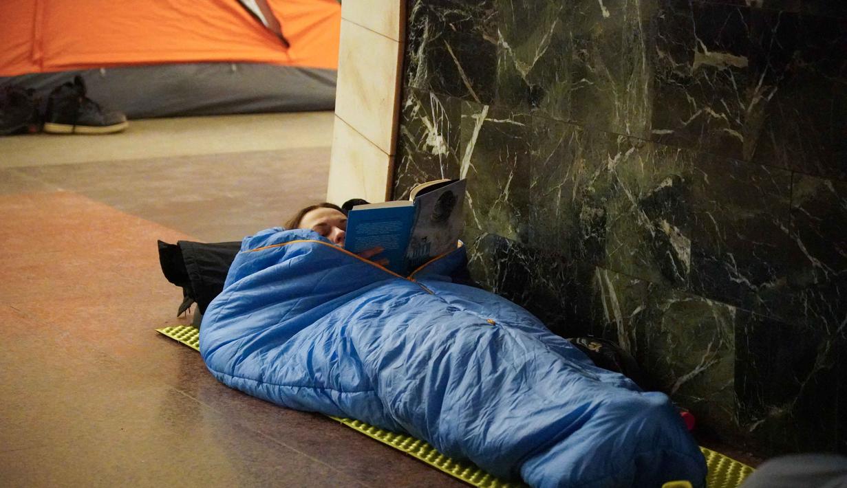 Ratusan drone dan puluhan rudal ditembakkan, menyebabkan gangguan pasokan listrik dan pemanasan di berbagai wilayah, termasuk Kyiv dan Kharkiv. Tampak dalam foto, seorang wanita dan seorang anak berlindung di stasiun metro selama serangan udara Rusia di Kyiv, pada Selasa 3 Februari 2026 pagi waktu setempat. (Serhii Okunev/AFP)