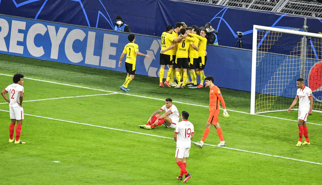 Para pemain Sevilla FC berdiri di lapangan dengan kecewa sementara pemain Borussia Dortmund merayakan gol Erling Haaland pada pertandingan leg kedua babak 16 besar Liga Champions di Dortmund, Jerman, Selasa (9/3/2021). Laga berakhir imbang 2-2. (AP Photo/Martin Meissner, Pool)
