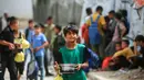 Seorang anak laki-laki Palestina yang mengungsi membawa sepanci makanan yang dikumpulkan dari dapur amal ke tempat penampungan keluarganya, di kamp pengungsi Bureij, Jalur Gaza Tengah pada Senin 18 Mei 2026. (Eyad Baba/AFP)
