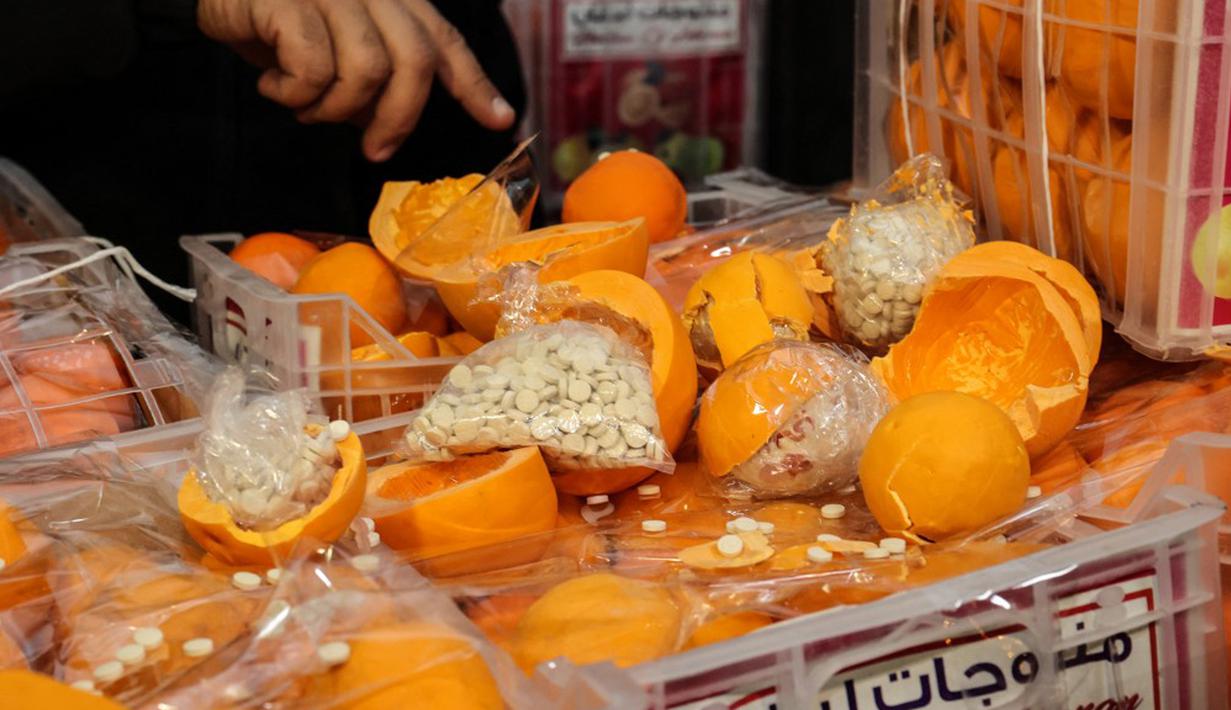 Seorang pria menunjukkan jeruk palsu berisi pil Captagon di Pelabuhan Beirut, Lebanon, 29 Desember 2021. Bea Cukai Lebanon menyita sembilan juta pil Captagon dalam jeruk palsu yang ditujukan ke salah satu negara Teluk. (ANWAR AMRO/AFP)