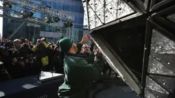 Pekerja memasang kristal berbentuk segitiga pada bola raksasa di atas sebuah gedung di Times Square, New York, Kamis (27/12). Menyaksikan bola kristal raksasa adalah tradisi yang tidak terlewatkan setiap perayaan tahun baru sejak 1904. (AP/Seth Wenig)