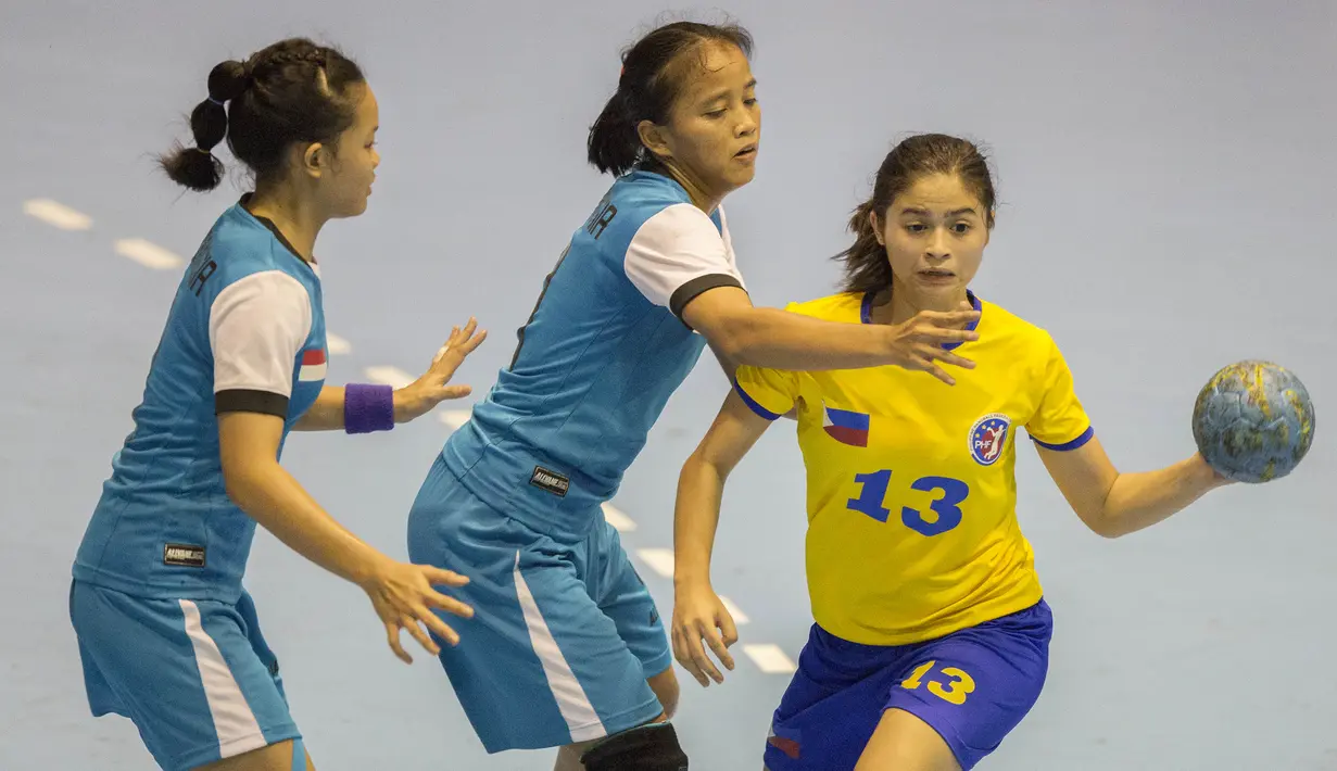 Pebola tangan putri Filipina, Dana Lora Schulte, berusaha melewati penjagaan ketat dari tim bola tangan putri Indonesia pada International Handball Federation Trophy 2016 di Jakarta, Sabtu (5/3/2016). (Bola.com/Vitalis Yogi Trisna)