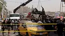 Petugas mengevakuasi bangkai mobil bekas ledakan serangan bom di Baghdad, Irak (30/5). Serangan bom ini meledak di dekat sebuah toko es krim populer di Kota Baghdad. (AP Photo / Karim Kadim)