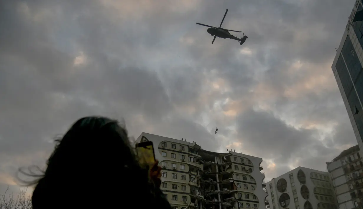 <p>Seorang anggota pasukan khusus mencoba mendaratkan helikopter di sebuah bangunan rusak yang diperkirakan berisi beberapa hewan di Diyarbakir, Turki tenggara (22/2/2023). Para pecinta hewan di kota Turki yang porak-poranda akibat gempa mematikan memprotes pada 22 Februari 2023, setelah pejabat berusaha menghancurkan bangunan rusak yang diduga berisi beberapa hewan, koresponden AFP melihat. (AFP/Ilyas Akengin)</p>