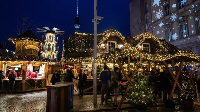 Pengunjung memadati stan di pasar Natal di Forum Humboldt Berlin, dengan Menara TV terlihat di latar belakang pada tanggal 19 Desember 2024 di Berlin, Jerman, selama musim liburan. John MACDOUGALL / AFP