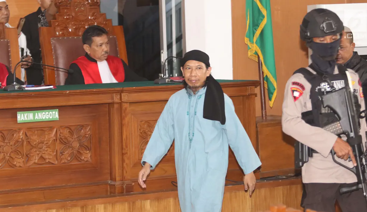 Terdakwa terorisme, Aman Abdurrahman menuju kursi pesakitan pada sidang pembacaan vonis di PN Jakarta Selatan, Jumat (22/6). Sesuai kesepakatan dengan KPI, persidangan tidak boleh disiarkan secara langsung di stasiun TV. (Liputan6.com/Angga Yuniar)