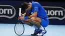 Petenis Serbia, Novak Djokovic, tertunduk lesu usai ditaklukkan Petenis Rusia, Daniil Medvedev, pada ATP Finals di O2 Arena, London, Kamis (19/11/2020). Petenis nomor satu dunia itu takluk 3-6 3-6. (AP/Frank Augstein)