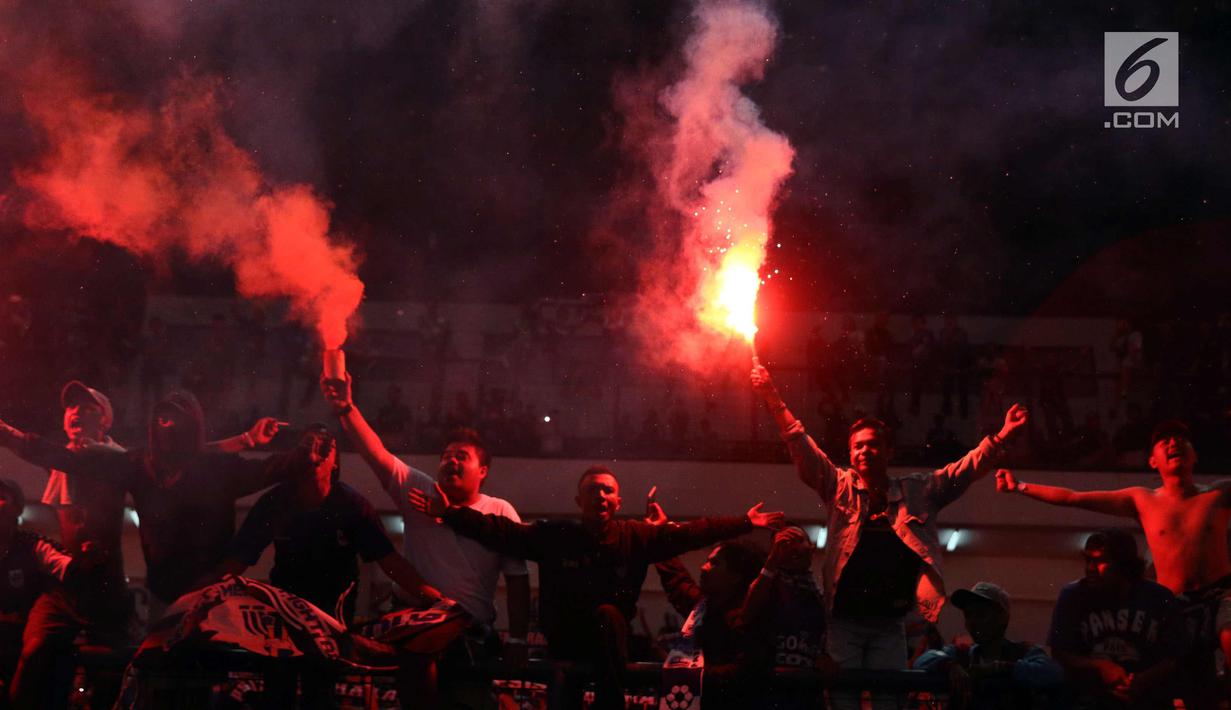 Suporter PSIS menyalakan suar saat merayakan kemenangan timnya melawan Martapura FC di Final tempat ketiga Liga 2 Indonesia di Stadion GBLA, Bandung, Selasa (28/11). PSIS unggul 6-4 dan lolos ke Liga 1 Indonesia. (Liputan6.com/Helmi Fithriansyah)