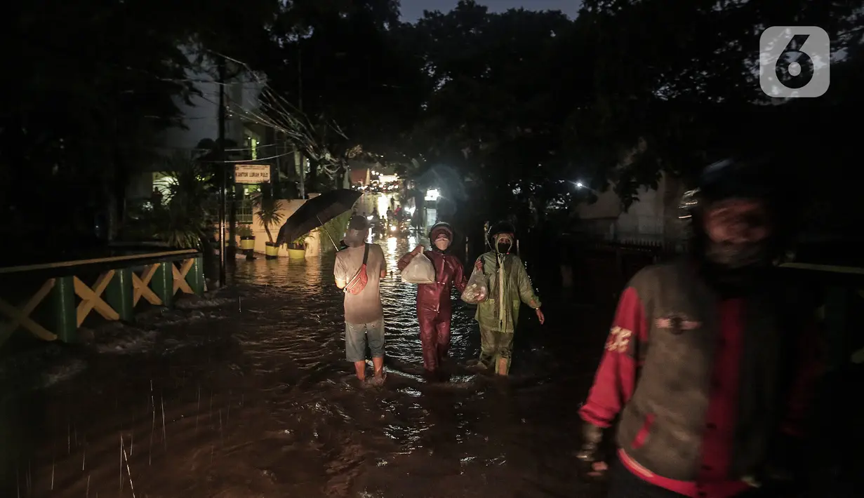 Warga melewati rumah yang tergenang banjir di jalan Bank, Jakarta Selatan, Selasa (4/10/2022). Hujan yang mengguyur wilayah Ibu Kota Jakarta mengakibatkan banjir menggenangi kawasan Kemang, Jakarta. (Liputan6.com/Johan Tallo)