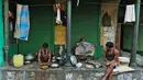 Sejumlah pekerja mempersiapkan makan pagi dan membaca koran di depan toko di Kolkata, India (26/5/2016). Kolkuta ialah ibu kota India antara 1833 sampai 1912  Terdapat Universitas Kolkata dan Museum India. (REUTERS/Rupak De Chowdhuri)