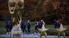 Para pemain timnas Prancis berjalan melewati relpika trofi Piala Dunia dan dua bintang saat bersiap berlatih di Clairefontaine-en-Yvelines (12/11). Prancis akan bertanding melawan Belanda di UEFA Nations League. (AFP Photo/Franck Fife)