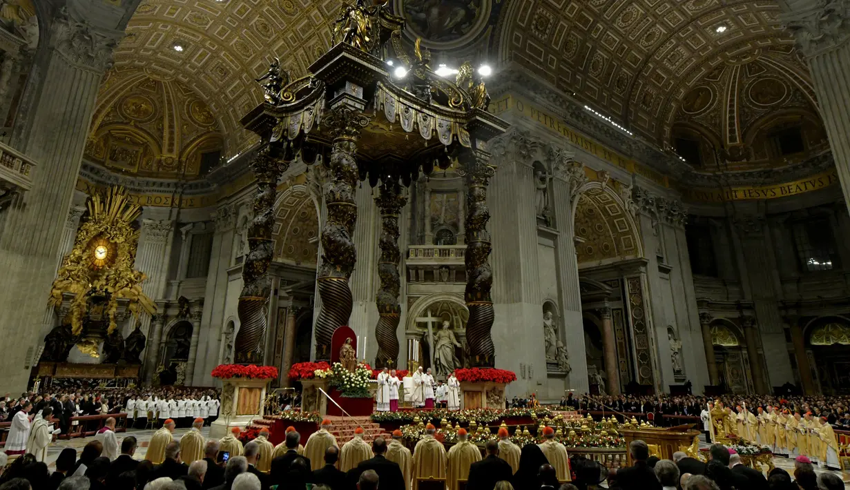 Suasana misa Natal di Basilika Santo Petrus, Vatikan, (24/12). Paus Fransiskus menyerukan kepada masyarakat di negara maju agar menjalani kehidupan yang sederhana dan tidak terlalu materialistis. (AFP Photo/Tiziana Fabi)